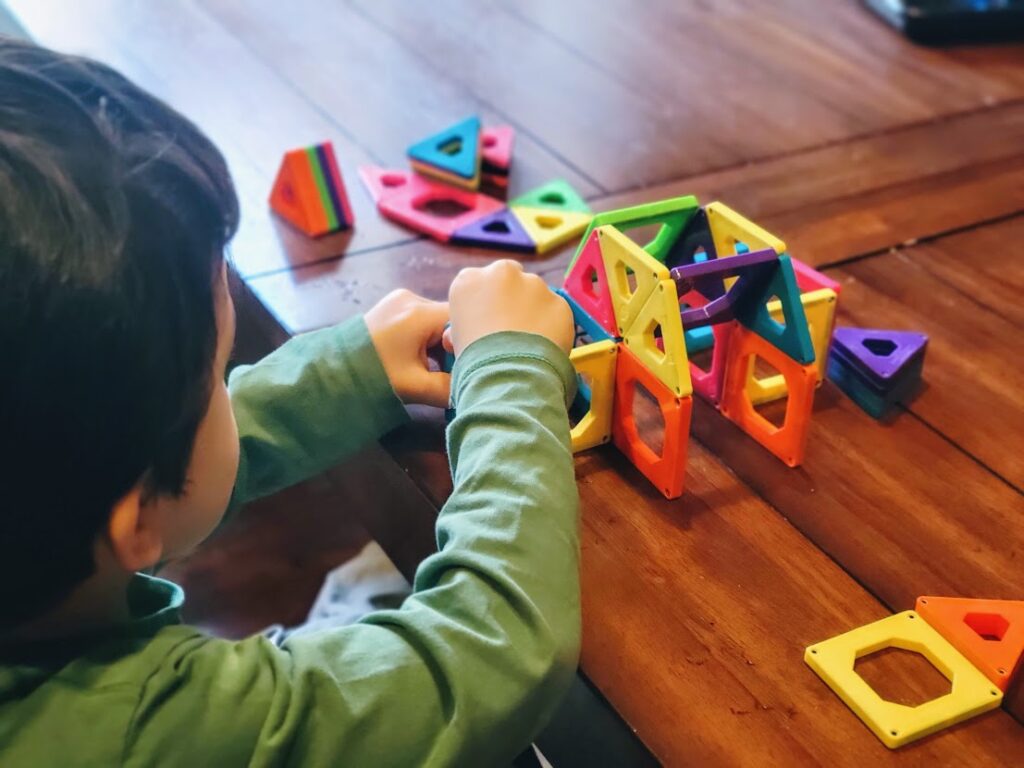 Child playing with magnetic tiles