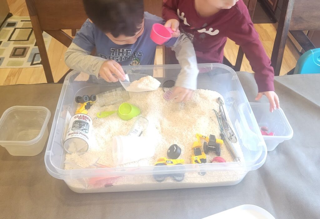 Children playing with a rice sensory bin