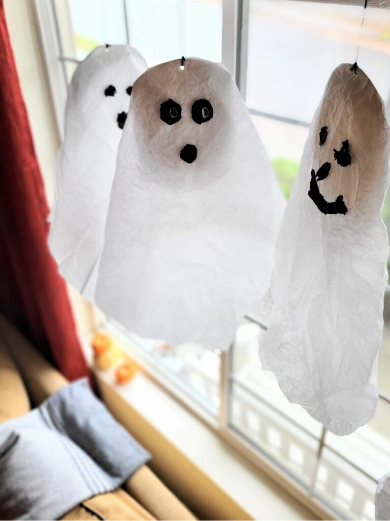 Tissue paper ghosts hanging in a window