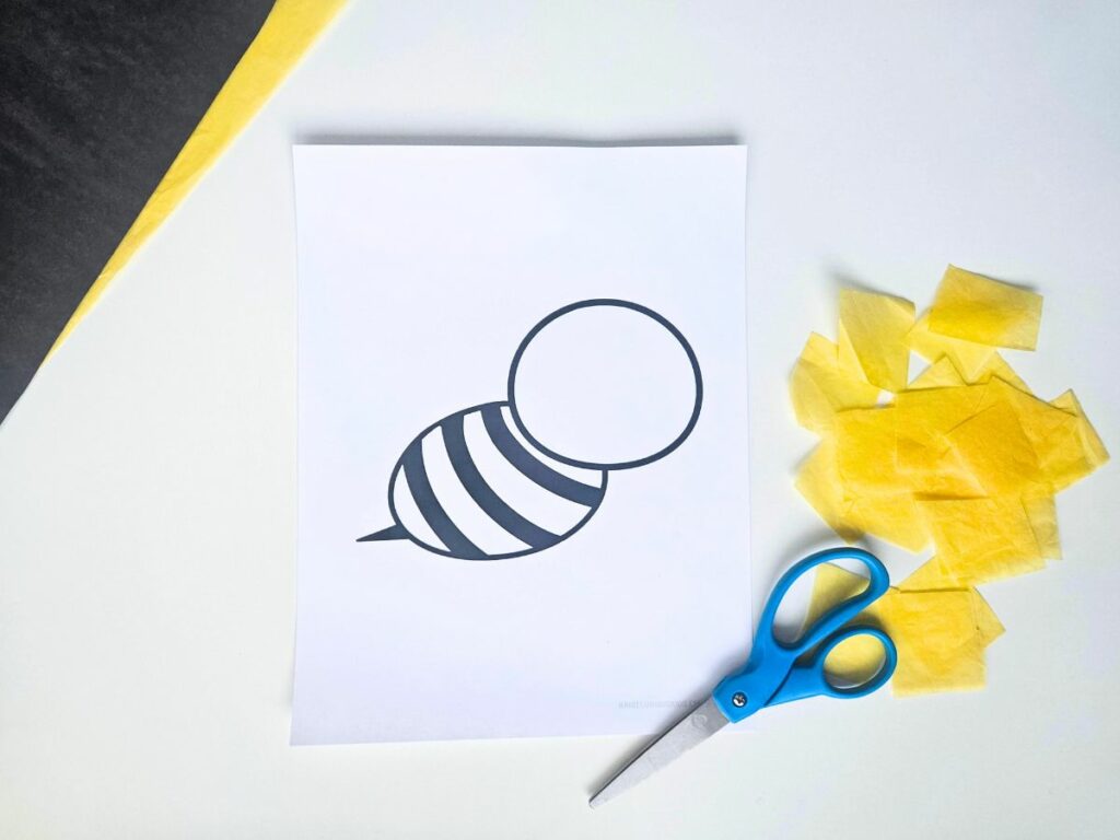 Yellow tissue paper cut into small squares next to bee printable