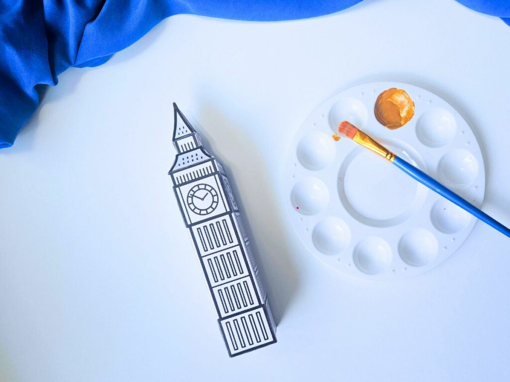 Assembled Big Ben 3D craft next to paint and a paintbrush