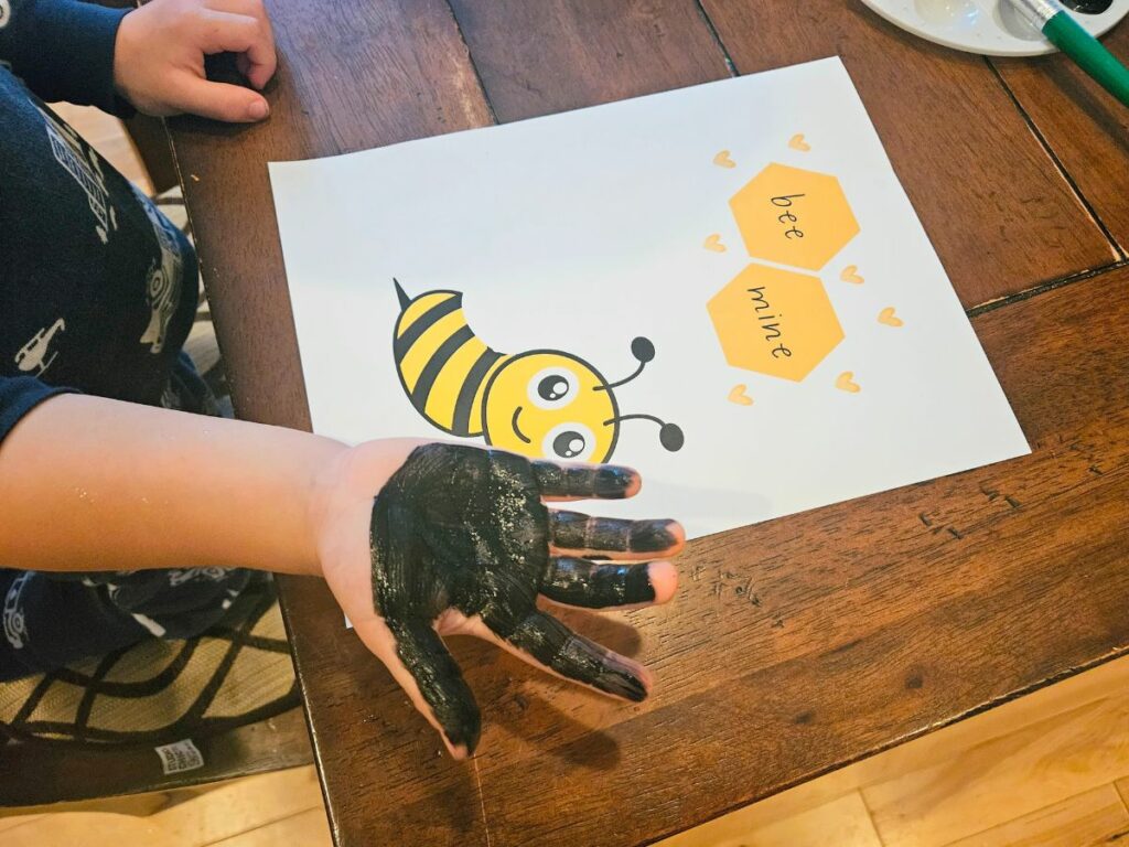 Child doing a bee mine handprint craft
