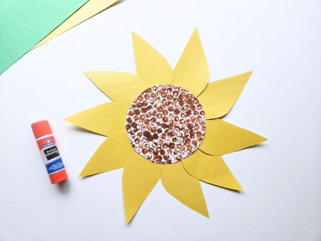 Putting the yellow petals on the sunflower paper plate craft